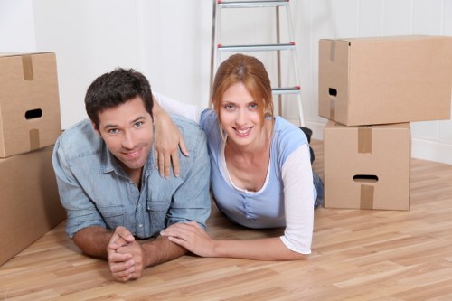Trained movers carrying boxes carefully in a Camden property
